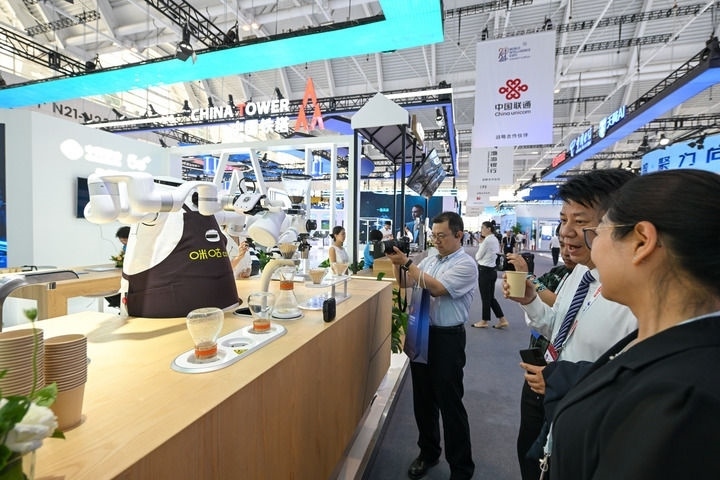 6月20日，與會(huì)者品嘗機(jī)器人沖調(diào)出的咖啡。新華社記者 孫凡越 攝