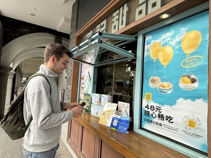 來(lái)自德國(guó)的留學(xué)生理查德在杭州西湖邊一家商鋪使用支付寶掃碼支付（2024年4月11日攝）。新華社發(fā)