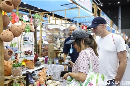 游客在蘭納博覽會特色展位上選購工藝品。人民網記者楊一攝