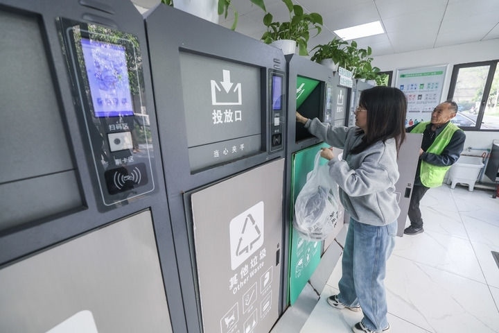 2024年4月10日，在浙江省湖州市吳興區(qū)飛英街道新華府小區(qū)內(nèi)，居民在垃圾分類智能系統(tǒng)的指導(dǎo)下進(jìn)行垃圾分類投放，居民的投放情況將實(shí)時匯總到智慧服務(wù)平臺，會有相應(yīng)的積分獎勵。新華社記者 徐昱 攝