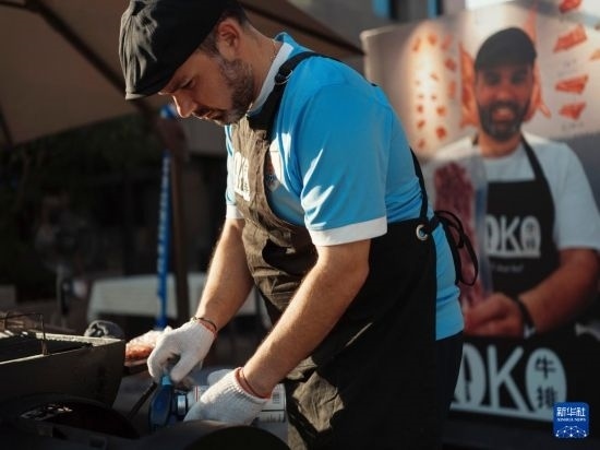 7月19日，在蕪湖古城，馬丁在當(dāng)天舉行的啤酒節(jié)上制作牛排。新華社發(fā)（繆雨晨 攝）
