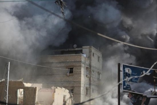 7月21日，在加沙地帶中部的努賽賴特難民營(yíng)，遭以軍空襲的建筑冒出滾滾濃煙。新華社發(fā)（馬爾萬(wàn)·達(dá)烏德攝）