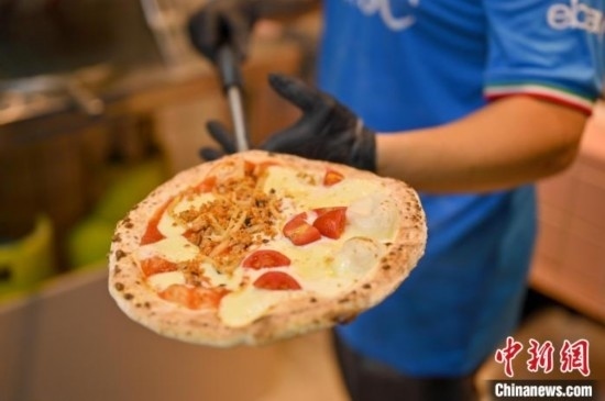 近日，韋榮耀展示他制作的“老友味”披薩。 俞靖 攝