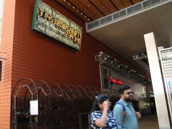 2023年5月29日，人們經(jīng)過(guò)美國(guó)紐約曼哈頓的“國(guó)債鐘”?！皣?guó)債鐘”是一個(gè)大型計(jì)數(shù)器，它實(shí)時(shí)更新美國(guó)的公共債務(wù)總額，并顯示出每個(gè)美國(guó)家庭所要負(fù)擔(dān)的數(shù)額。 新華社記者劉亞南攝