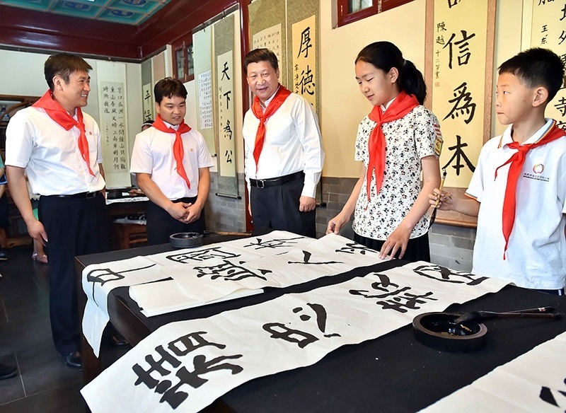 2014年5月30日，習近平總書記來到北京市海淀區(qū)民族小學，參加慶祝“六一”國際兒童節(jié)活動。這是總書記觀看學生書寫的毛筆字。