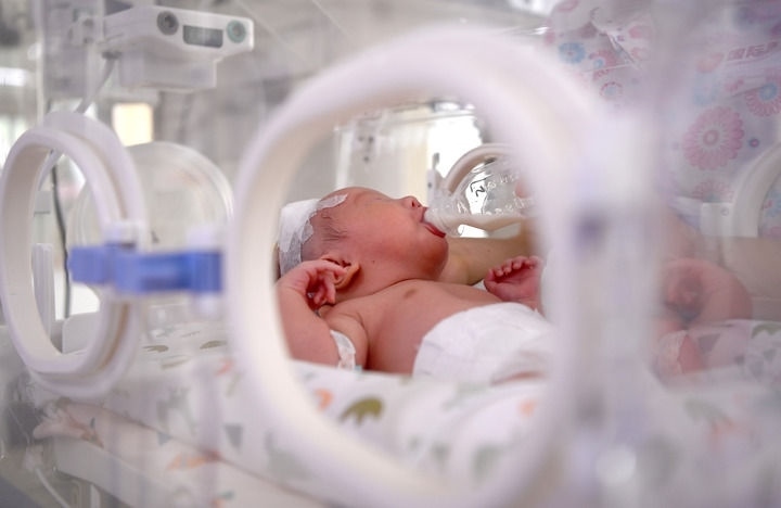 2024年6月1日，在西安國際醫(yī)學(xué)中心醫(yī)院新生兒科病房，護(hù)士為新生兒喂奶。 新華社記者 劉瀟 攝