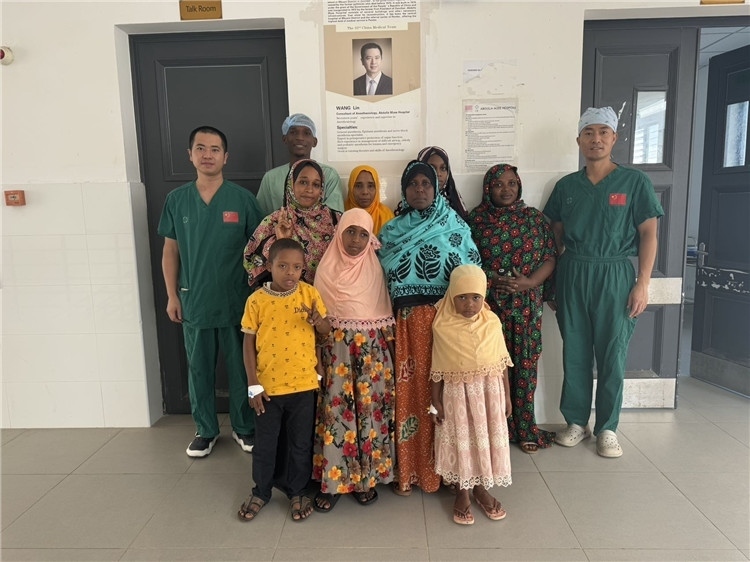 李廣（右一）和王林醫(yī)生與部分患者合影。中國援桑醫(yī)療隊供圖