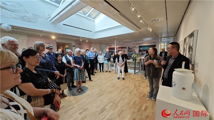 參展人、景德鎮(zhèn)陶瓷大學美術學院副院長邵長宗（右一）向來賓介紹參展作品。人民網(wǎng)記者 殷淼攝