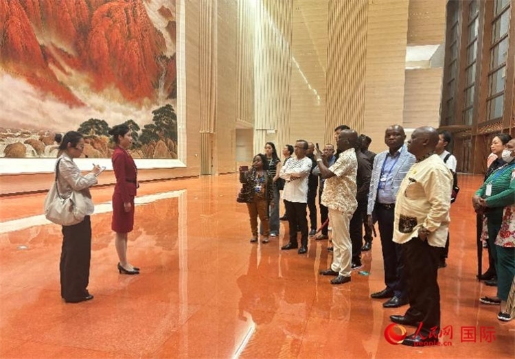 代表團(tuán)在入口處聽取講解。人民網(wǎng) 曹欣悅攝