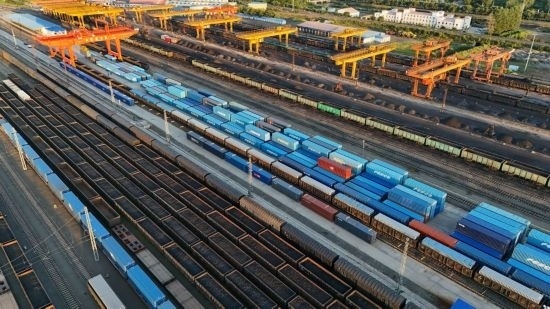 這是2024年8月14日在黑龍江綏芬河鐵路口岸集裝箱換裝場拍攝的集裝箱換裝作業(yè)現(xiàn)場（無人機(jī)照片）。今年前七個(gè)月，綏芬河鐵路口岸開行中歐班列573列，運(yùn)量達(dá)55246標(biāo)箱，同比分別增長23%和18%，班列數(shù)量持續(xù)保持高位運(yùn)行。