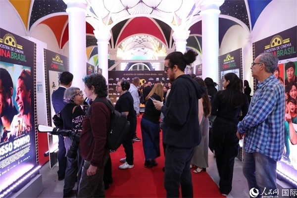 為期4天的第三屆中國－巴西電影展期間，來自中巴兩國的14部參展影片受到巴西電影愛好者和社會各界人士好評，圖為當?shù)赜^眾在影展舉辦地巴西里約熱內盧勞拉—阿爾維姆文化之家的迎賓廳欣賞參展電影海報。 人民網記者 陳一鳴攝