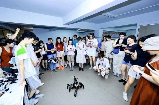 8月25日，中外青年在浙江杭州觀看機器人表演。新華社發(fā)（清華大學(xué)供圖）