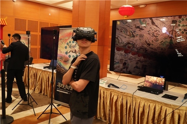 1、在本次活動的展覽現(xiàn)場，敦煌研究院與騰訊展示了“數(shù)字藏經(jīng)洞”和“尋境敦煌”等創(chuàng)新互動產(chǎn)品。圖為當?shù)孛癖娡ㄟ^VR虛擬游覽洞窟。 人民網(wǎng)記者 李志偉攝