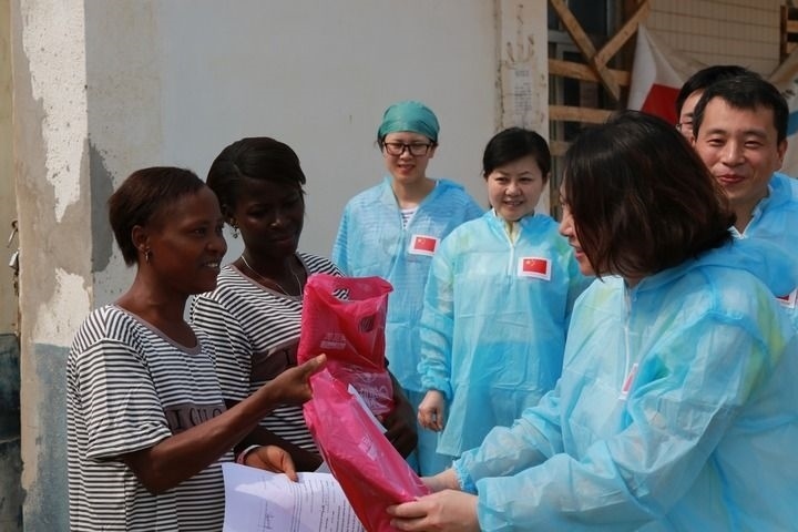 2015年4月4日，在位于塞拉利昂首都弗里敦市郊的中塞友好醫(yī)院埃博拉診療中心，中國第四批援塞醫(yī)療隊副隊長邵蔚（右前）向被治愈的埃博拉出血熱患者贈送禮物。新華社發(fā)（祖榮強(qiáng) 攝）