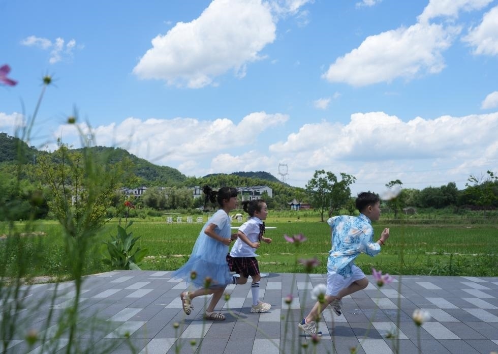 兒童在余姚市梁弄鎮(zhèn)的田野間奔跑（7月3日攝）。新華社記者翁忻旸 攝