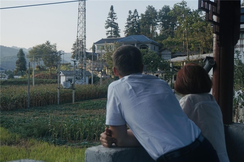 望得見山，看得見水，記得住鄉(xiāng)愁。每個人心中都有一個屬于自己的“花茂村”，在這方心田，走遍千山萬水，鄉(xiāng)音未改鬢毛衰。吉爾吉斯斯坦《比什凱克晚報》第一副總編輯妮娜·尼奇博洛娃與《中國與俄羅斯》雜志社社長奧列格·別列日內赫攝在花茂村民居屋檐下并肩佇立，眺望山水，尋覓鄉(xiāng)愁。（李光裕攝）