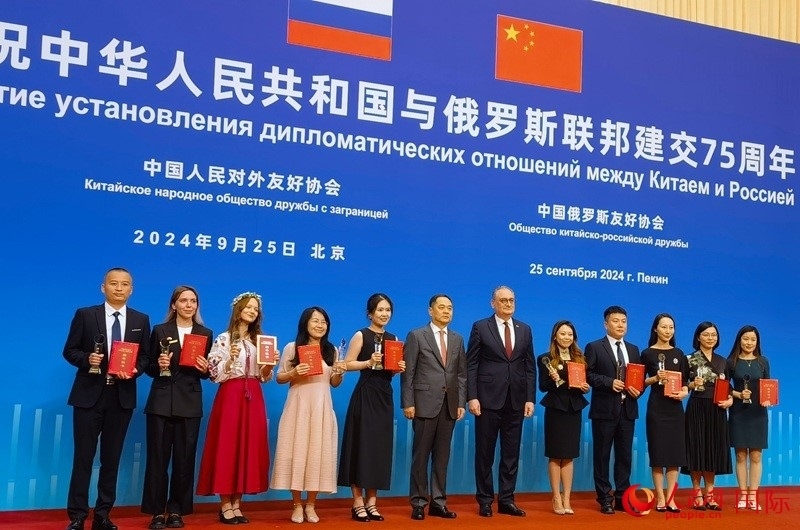 楊萬明會長和莫爾古洛夫大使為10位中俄青年友好微視頻創(chuàng)意大賽獲獎代表頒獎。人民網(wǎng)記者 李明琪攝