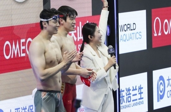  10月18日，汪順（左）和潘展樂在男子100米混合泳決賽后。新華社記者 方喆 攝
