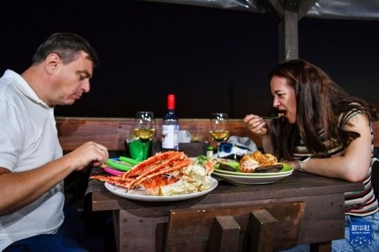 9月2日，食客們在俄羅斯符拉迪沃斯托克的一家餐館品嘗帝王蟹。新華社記者 曹陽 攝