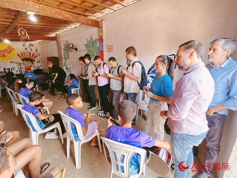  受益于中國企業(yè)的“青少年成長”項目，700多名當(dāng)?shù)厍嗌倌甑囊魳泛妥闱驂粝氩迳狭顺岚?。圖為聯(lián)合采訪團正在采訪參加音樂培訓(xùn)的孩子們。 人民網(wǎng)記者 陳一鳴攝