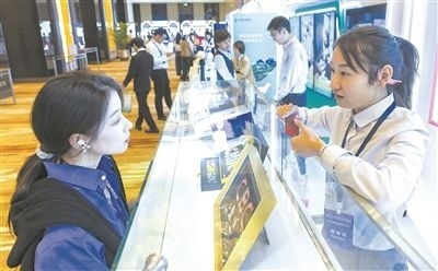 在北京麗澤商務(wù)區(qū)，工作人員（右一）介紹數(shù)字人民幣SIM卡硬錢包。新京報記者 陶冉攝