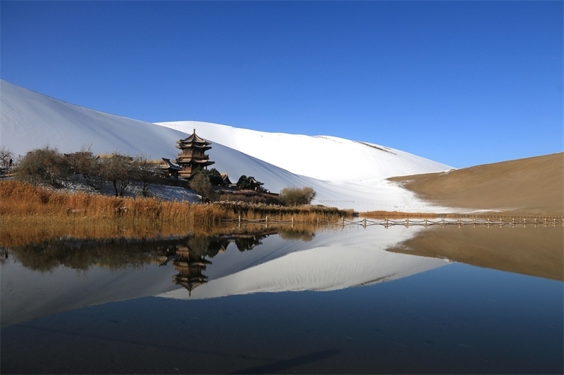 鳴沙山月牙泉景區(qū)雪景。敦煌市委宣傳部供圖，張曉亮攝