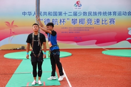 11月23日，工作人員為上海隊選手付樂樂（左）系安全繩。新華社記者 楊植森 攝