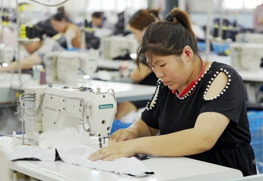 5月20日，村民在李寨村服裝加工廠內(nèi)忙碌。河南省周口市沈丘縣馮營鎮(zhèn)李寨村地處豫東平原。近年來，乘著脫貧攻堅與鄉(xiāng)村振興政策的東風，李寨村積極探索產(chǎn)業(yè)發(fā)展模式，通過“龍頭企業(yè)+村集體經(jīng)濟+農(nóng)戶”的方式，逐漸發(fā)展形成肉牛養(yǎng)殖、設施農(nóng)業(yè)、服裝加工、康養(yǎng)民宿等產(chǎn)業(yè)，以產(chǎn)業(yè)振興助力鄉(xiāng)村振興。新華社記者 李嘉南 攝