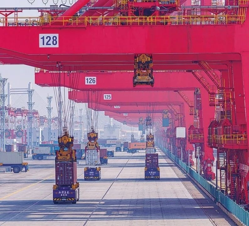 共建“一帶一路”國(guó)家在工作制度對(duì)接、技術(shù)標(biāo)準(zhǔn)協(xié)調(diào)、檢驗(yàn)結(jié)果互認(rèn)等方面強(qiáng)化合作、統(tǒng)一標(biāo)準(zhǔn)，貿(mào)易自由化便利化水平不斷提升。上海洋山港海關(guān)對(duì)接共建國(guó)家進(jìn)出口貨物相關(guān)標(biāo)準(zhǔn)，推動(dòng)通關(guān)一體化方式申報(bào)，提升通關(guān)效率。圖為無(wú)人駕駛的全自動(dòng)導(dǎo)引車(chē)在洋山港穿梭往來(lái)，搬運(yùn)集裝箱。王初 攝