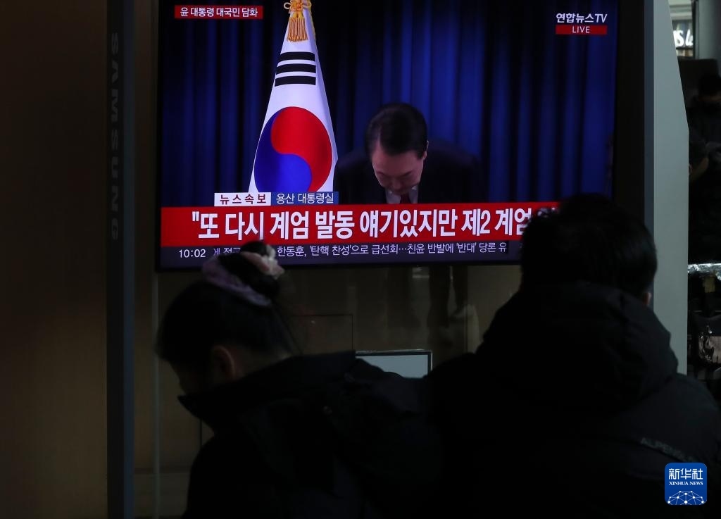 12月7日，在韓國首爾火車站，民眾觀看總統(tǒng)尹錫悅發(fā)表講話的電視畫面。新華社記者 姚琪琳 攝