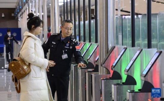1月2日，大興機(jī)場(chǎng)邊檢站警察指導(dǎo)旅客使用自助出境設(shè)備。新華社記者 李欣 攝