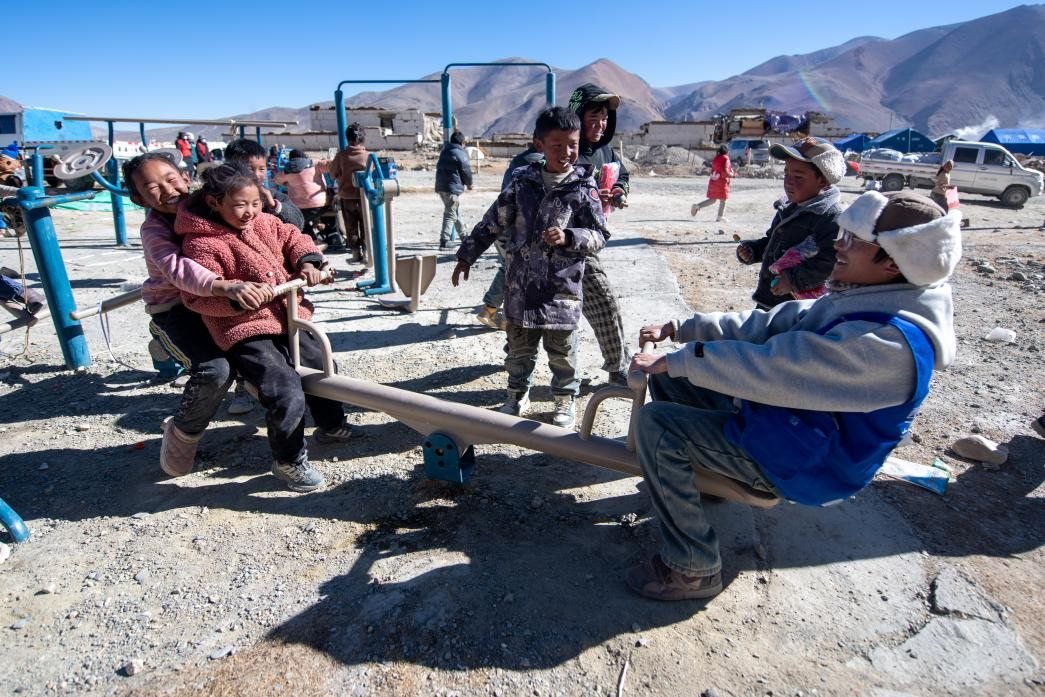 1月11日，在定日縣措果鄉(xiāng)塘仁村安置點(diǎn)，西藏星光社會(huì)工作服務(wù)中心志愿者和孩子們一起玩耍，進(jìn)行災(zāi)后心理疏導(dǎo)。人民網(wǎng)記者 翁奇羽攝