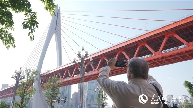 軻寶華“打卡”重慶東水門長江大橋。人民網(wǎng)記者 蘇纓翔攝