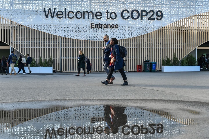 2024年11月15日，在阿塞拜疆首都巴庫，人們經(jīng)過聯(lián)合國氣候變化巴庫大會的會場。新華社記者 曹陽 攝