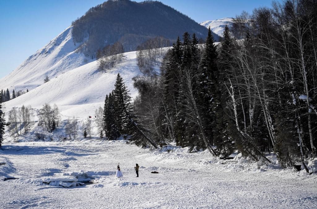 2024年2月5日，兩名游客在新疆阿勒泰地區(qū)布爾津縣禾木村拍照。新華社記者 馬鍇 攝