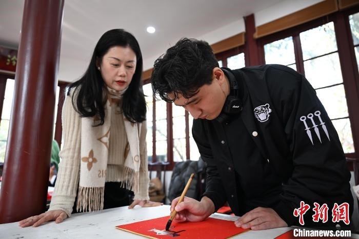 1月20日，外籍留學生在西泠印社社員李硯指導下寫福。當日，來自巴西、馬來西亞、加納、哈薩克斯坦的外籍留學生在浙江杭州西泠印社體驗福貼、春聯(lián)和篆刻，感受古老的中國傳統(tǒng)文化。中新社記者 王剛 攝