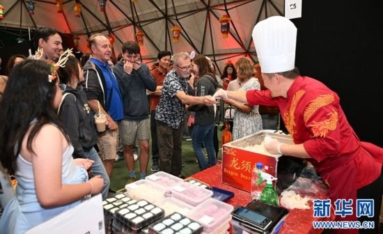 圖為游客在燈節(jié)現(xiàn)場(chǎng)購(gòu)買小吃。（圖片由奧克蘭中國(guó)文化中心提供）