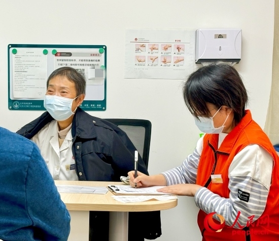 秦苑（中）接診患者。人民網(wǎng)記者 金慧慧攝