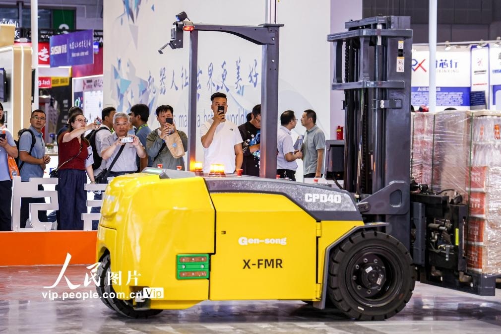 第24屆中國(guó)工博會(huì)現(xiàn)場(chǎng)，觀眾觀看叉取機(jī)器人作業(yè)演示。王初攝（人民圖片網(wǎng)）