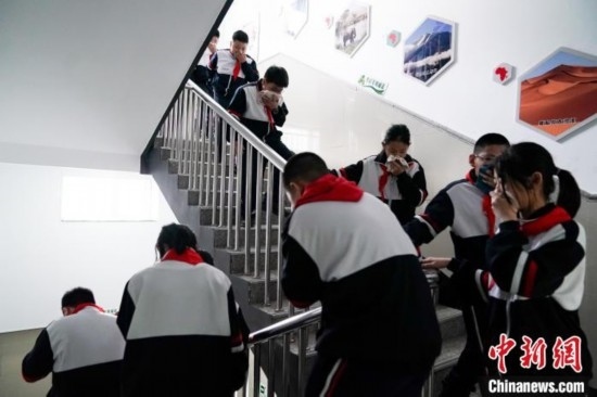  圖為學(xué)生們進(jìn)行應(yīng)急疏散演練。中新社記者 趙宇航 攝