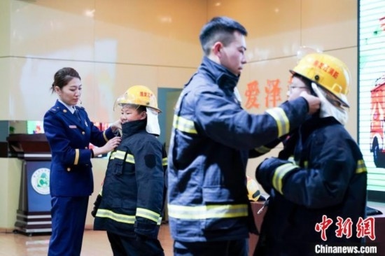 圖為學(xué)生們現(xiàn)場穿戴消防頭盔和戰(zhàn)斗服。中新社記者 趙宇航 攝