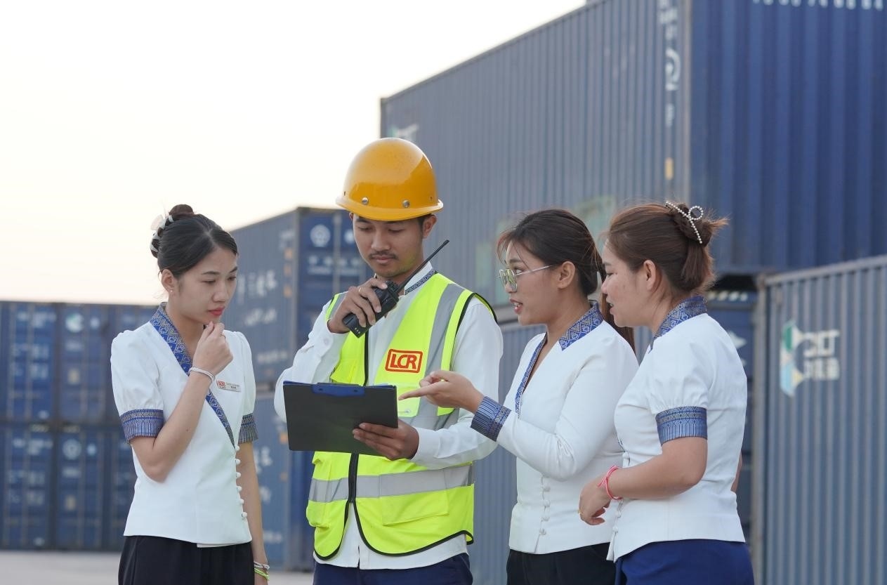 萬(wàn)象南站貨運(yùn)值班員陳尼啦（左一）與同事在一起討論工作。老中鐵路有限公司供圖