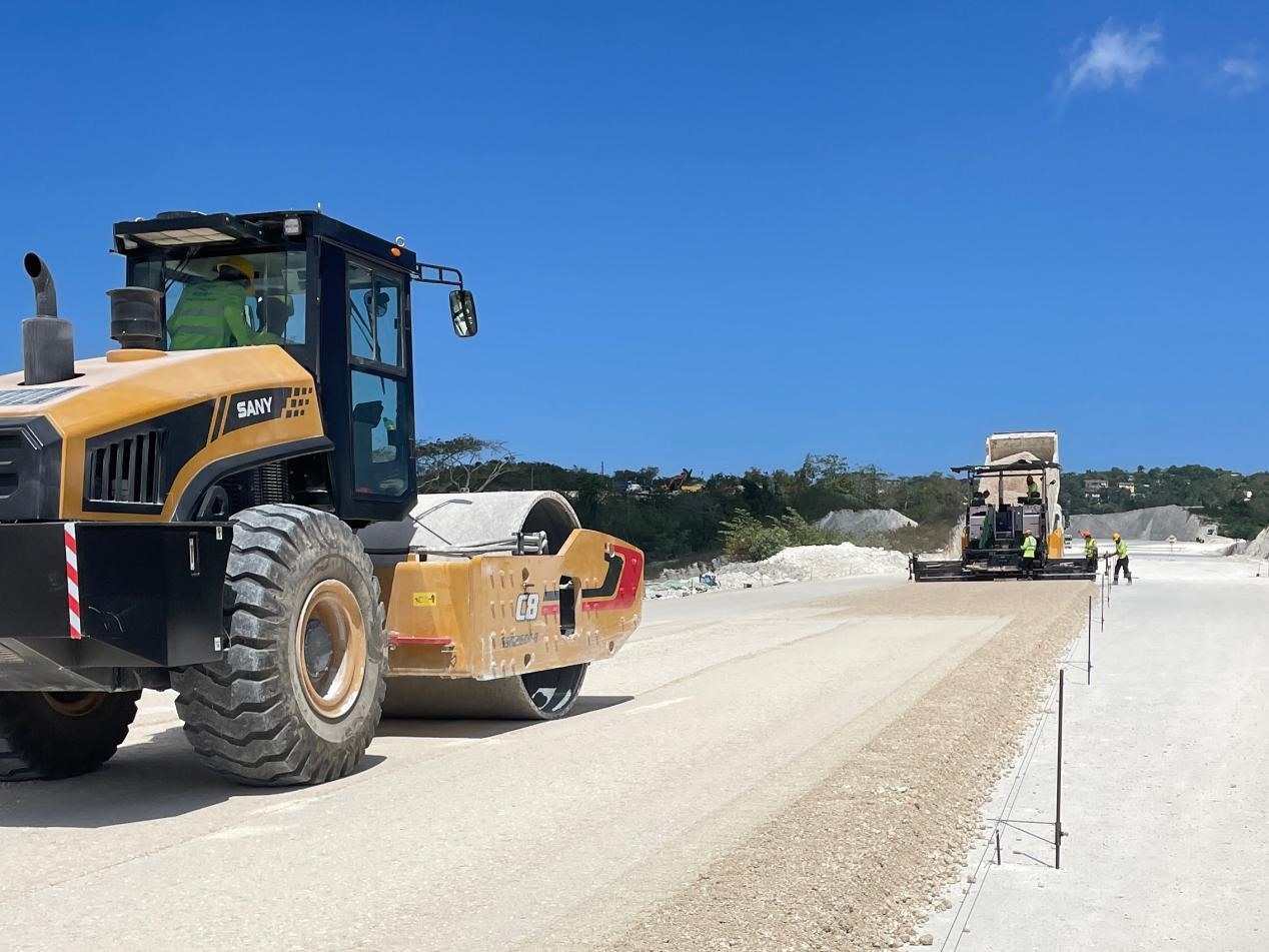 圖為中企承建的牙買(mǎi)加蒙特哥貝繞城路項(xiàng)目基層試驗(yàn)段正在進(jìn)行攤鋪和碾壓施工，相關(guān)施工工作已于日前順利完成。中國(guó)港灣美洲區(qū)域公司供圖