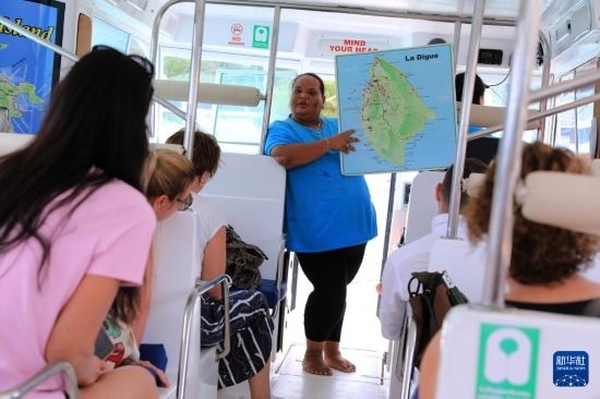 3月15日，一名導(dǎo)游在游艇上為游客介紹塞舌爾拉迪格島。新華社記者 董江輝 攝