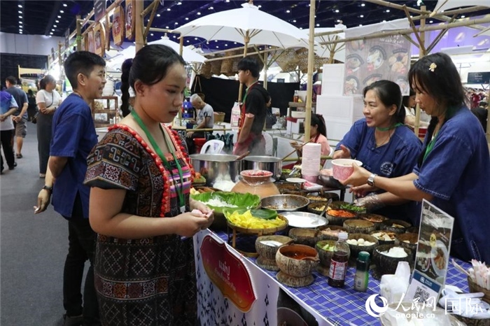 游客在攤位前購買特色美食。朱瀟逸攝