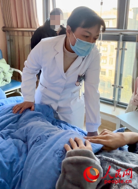 鄧茜查房時(shí)詢問患者情況。人民網(wǎng)記者 金慧慧攝