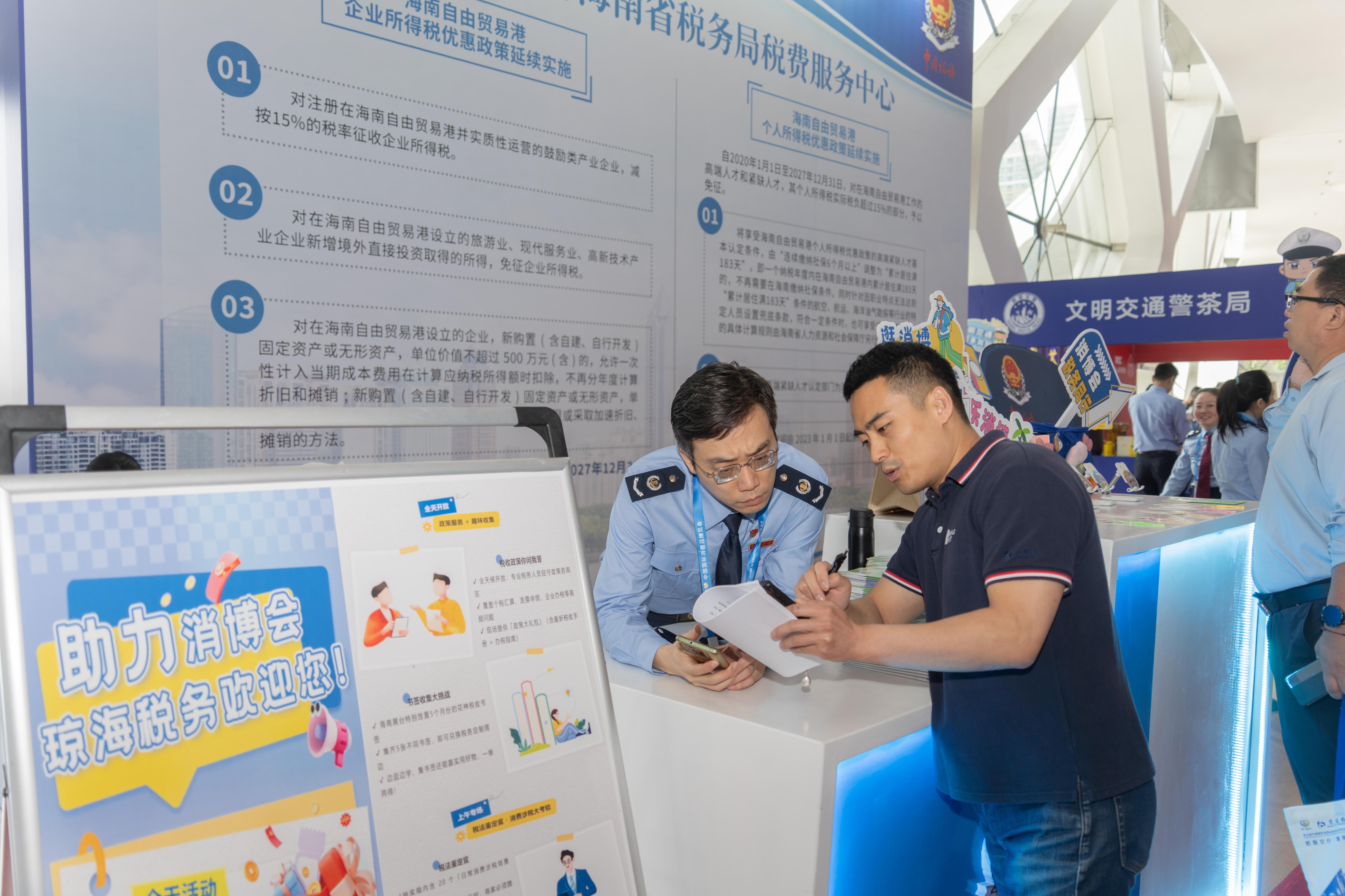 稅務(wù)服務(wù)臺工作人員向記者介紹服務(wù)參展外商的具體舉措。人民網(wǎng)記者 許崢攝