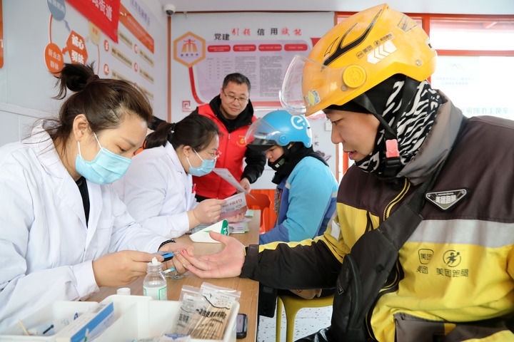 2025年3月5日，志愿者在山東省棗莊市市中區(qū)一工會(huì)驛站為外賣員免費(fèi)測(cè)量血糖。新華社發(fā)（王海楠攝）