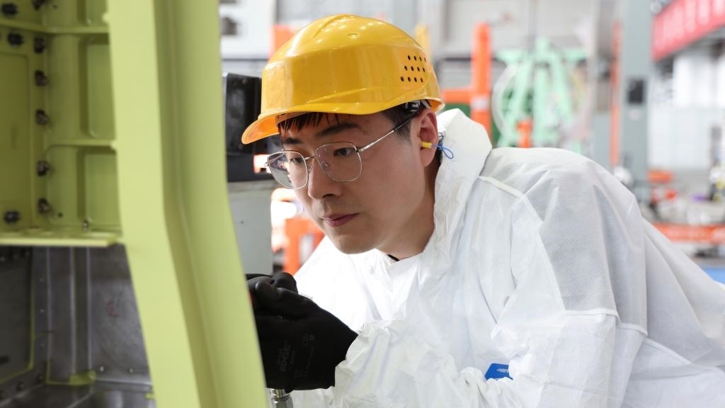 在中國(guó)航空工業(yè)集團(tuán)成飛車(chē)間內(nèi)，飛機(jī)鉚裝鉗工首席操作技師馮攀龍正在工作。（新華社發(fā)）