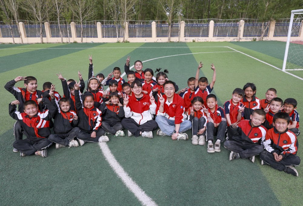 4月23日，在新疆克州阿圖什市哈拉峻鄉(xiāng)謝依特小學，支教教師王俊文（中左）、李軻凡（中右）和學生在一起。